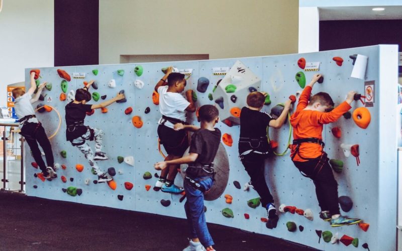 kids climbing up rock wall making progress