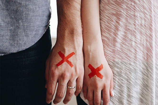 Couple with X's on hands